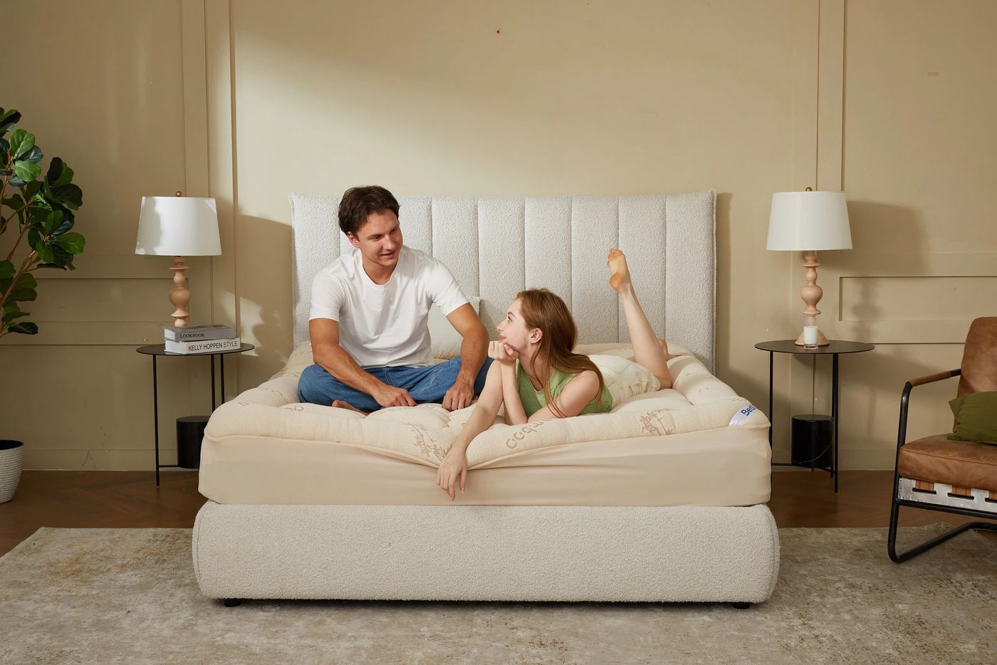 Pareja sentada sobre la cama con el topper beige